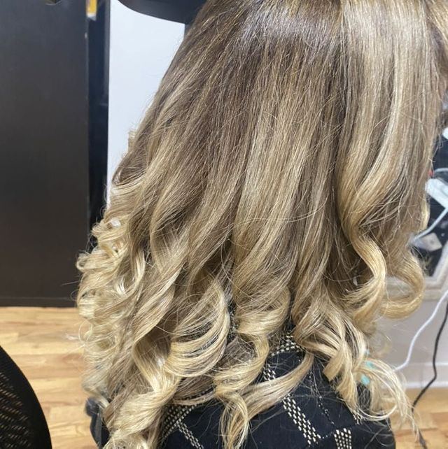 Curled blonde highlights, women's hair styling at Masih.